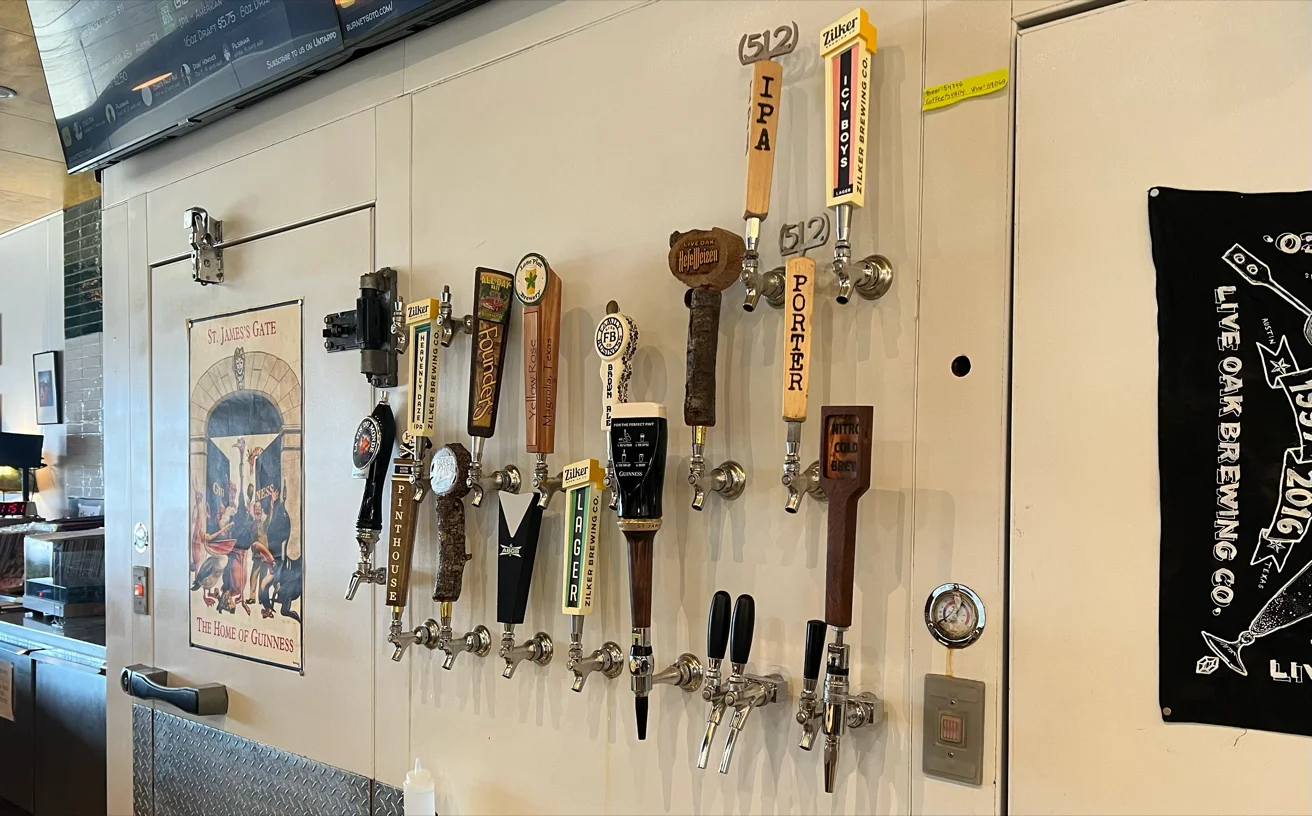 A white wall featuring many beer and nitro cold brew taps.