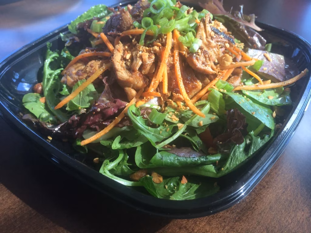 Salad with mixed greens, cooked meat, carrots, peanuts, green onions.