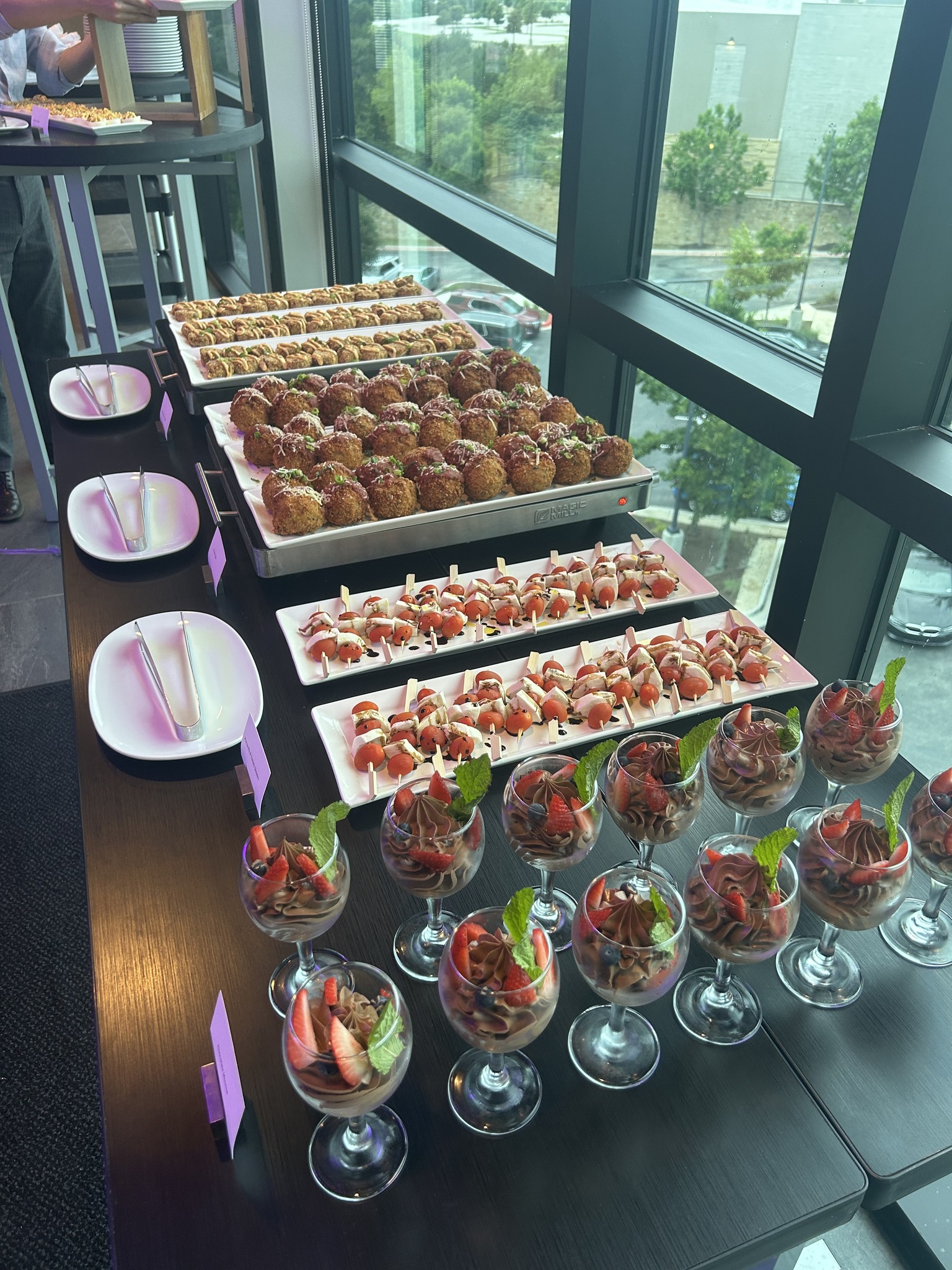 Buffet spread with appetizers, caprese skewers, and chocolate mousse desserts.
