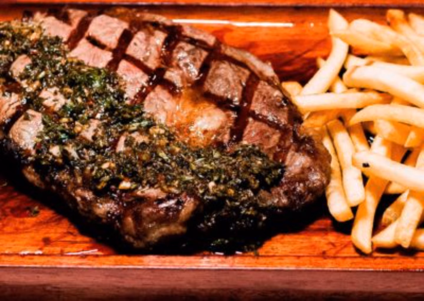 Grilled steak with herb sauce and golden french fries.