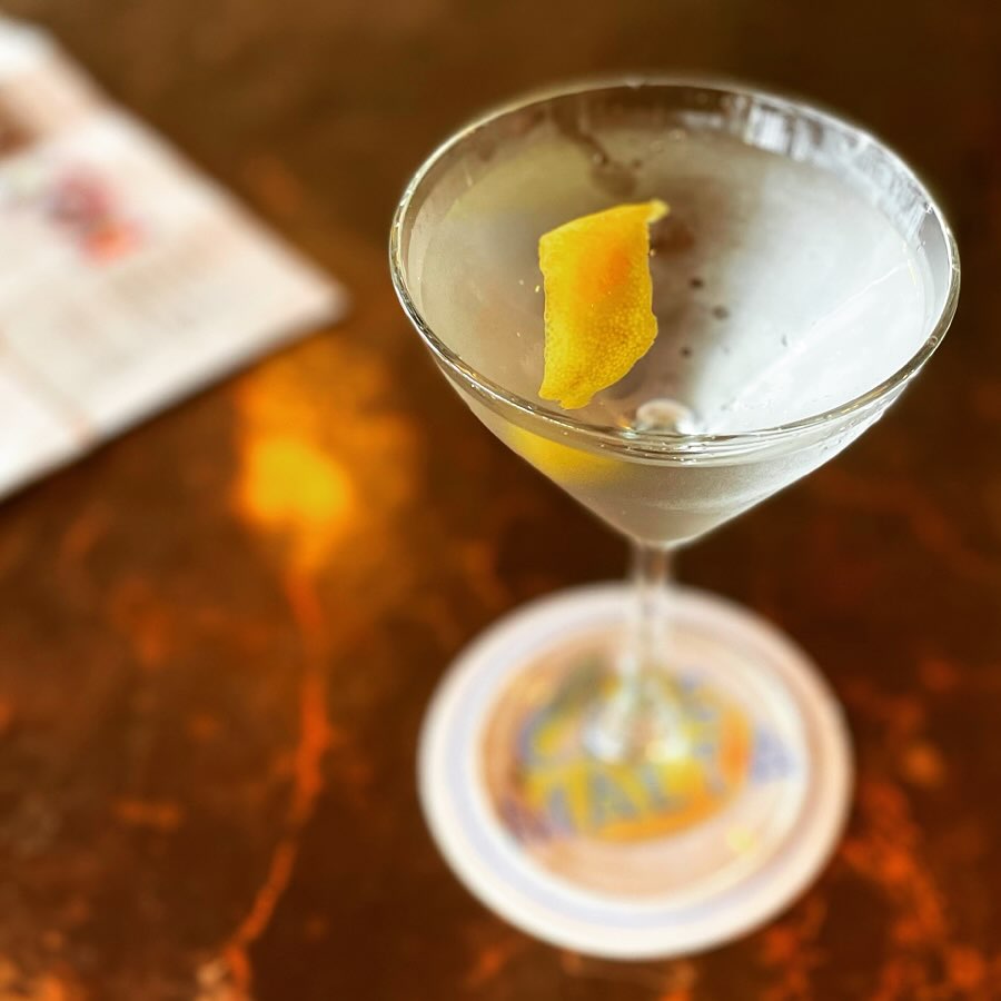 Martini glass with lemon twist on a coaster.