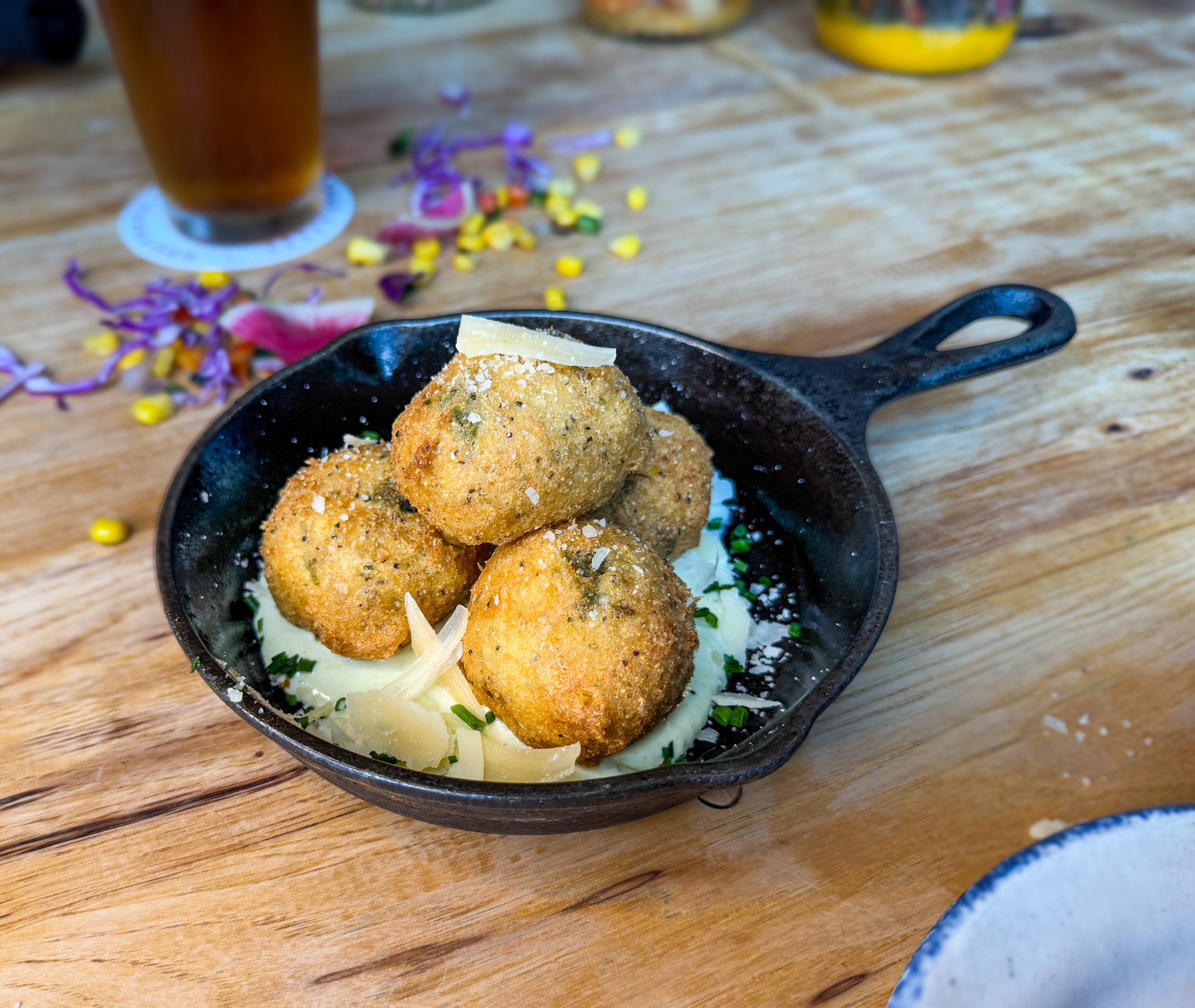 Golden-fried balls with creamy sauce and cheese in a mini skillet.