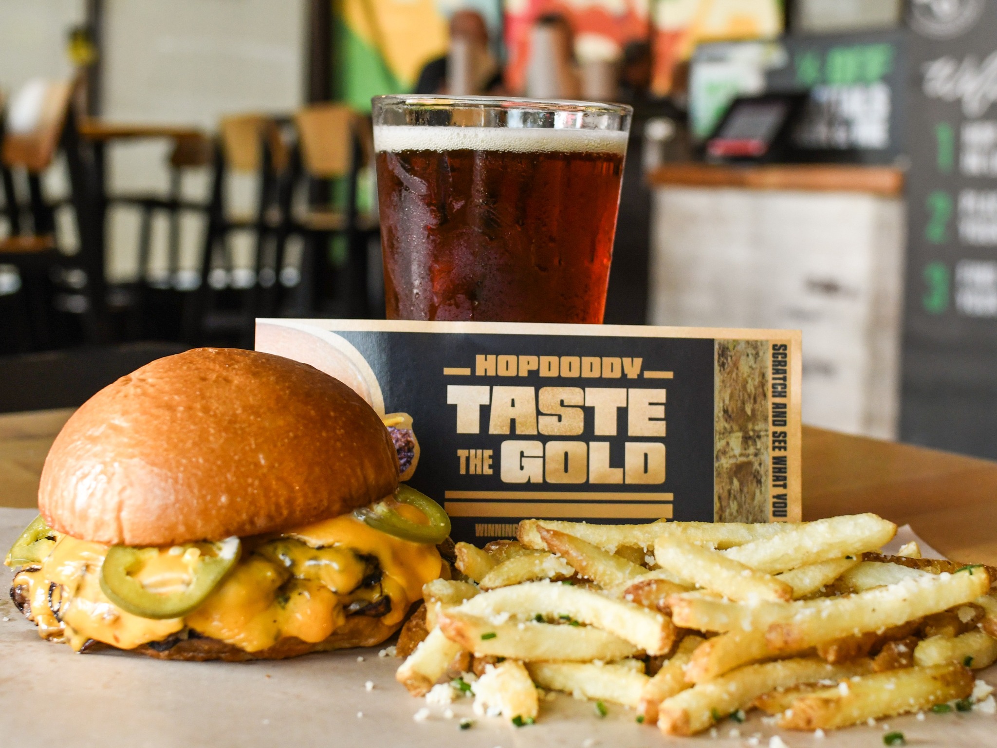 Jalapeño cheeseburger, fries, dark beer, and Hopdoddy scratch ticket.