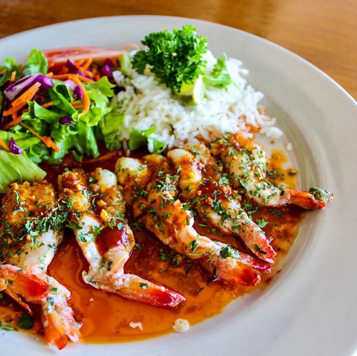 Cooked shrimp in sauce, white rice, and fresh green salad.