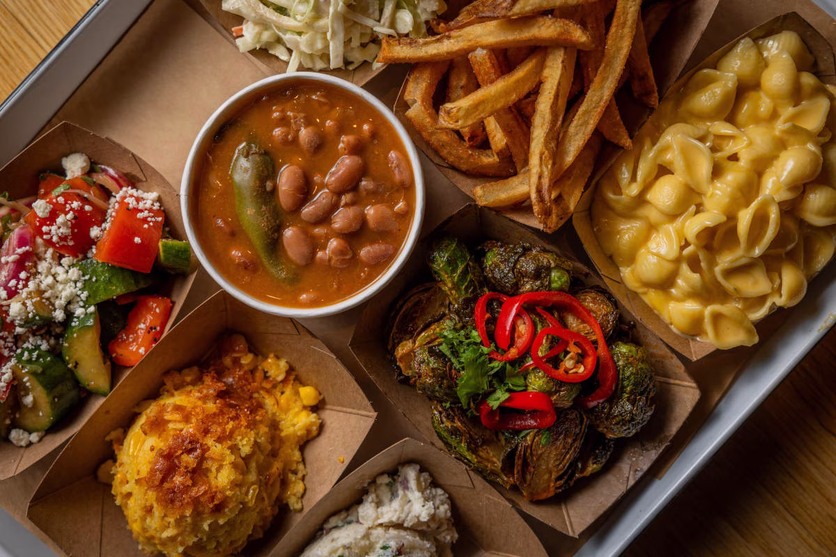 A tray of diverse American food, including beans, fries, and mac n cheese.