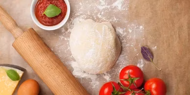 Ball of dough, rolling pin, sauce, tomatoes, cheese, and egg.