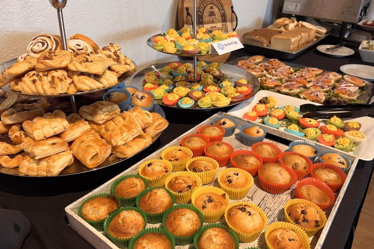 Buffet with pastries, muffins, deviled eggs, and salmon appetizers.