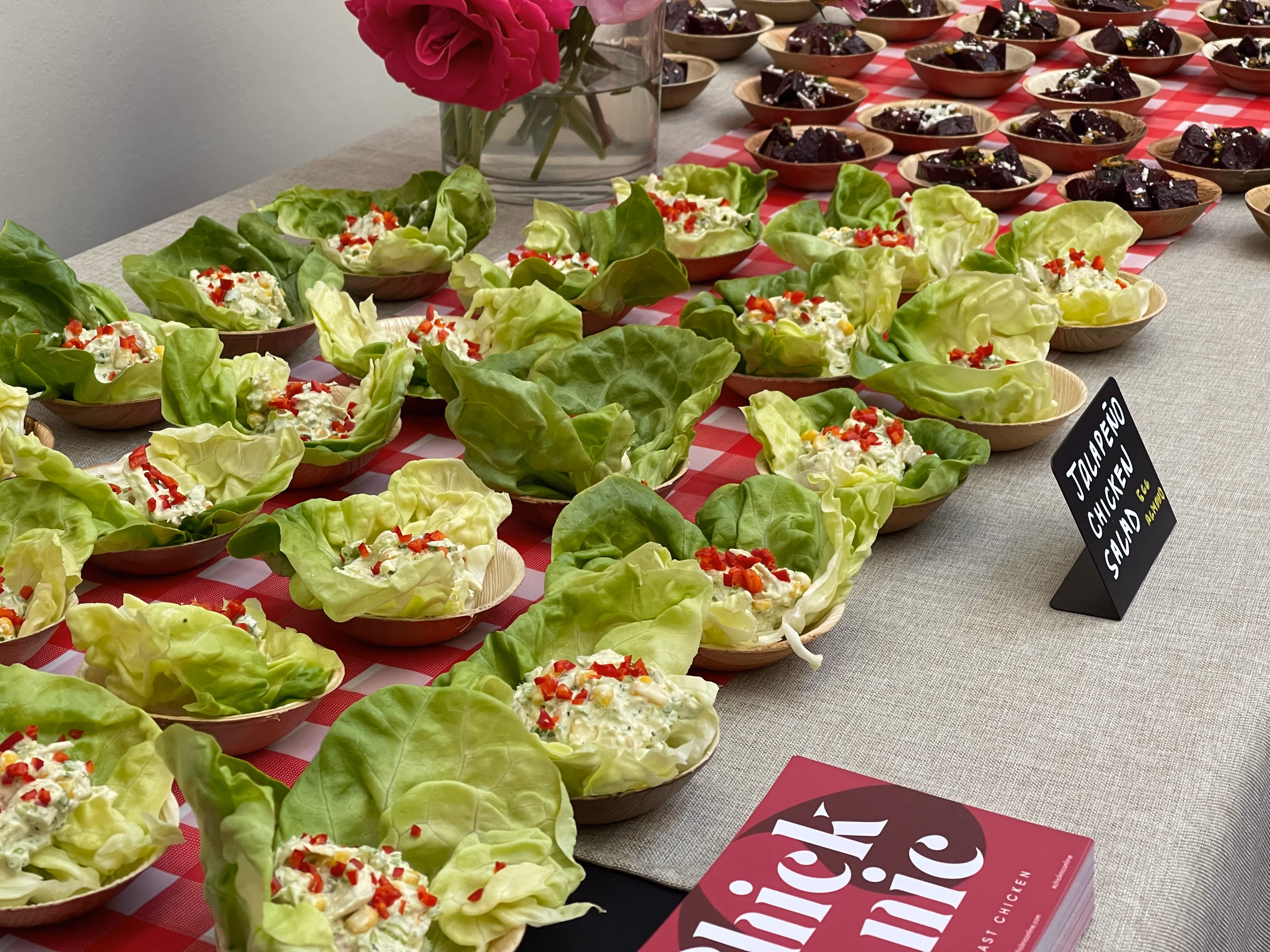 Jalapeño chicken salad lettuce cups and beet dishes on a checkered table.
