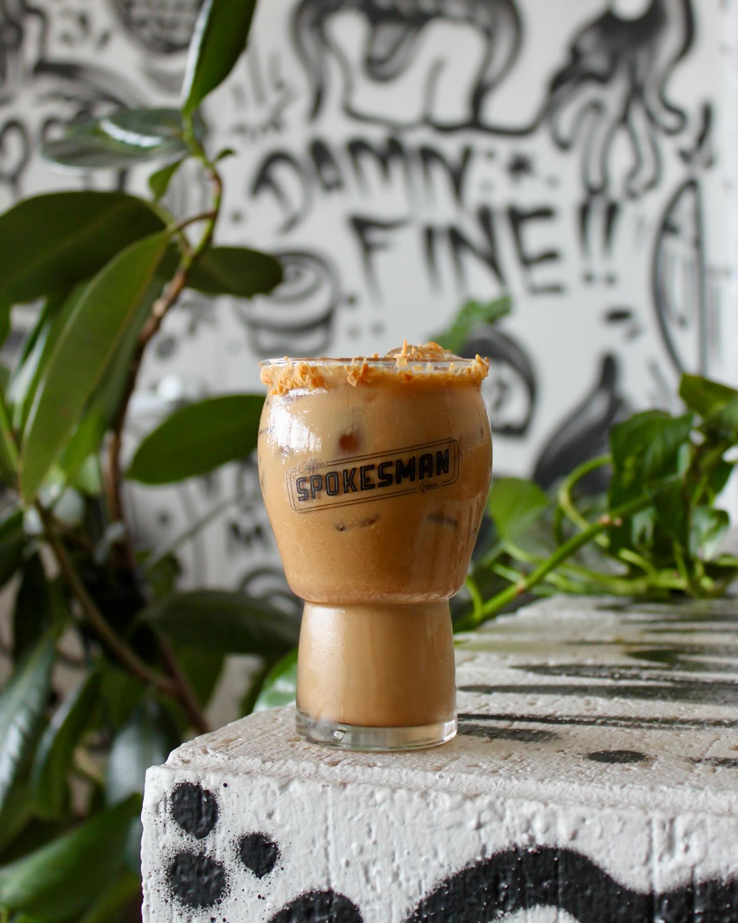 Iced coffee in Spokesman glass with textured rim on white block.