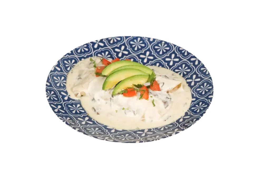 Dish with creamy sauce, avocado, and salsa on a patterned plate.