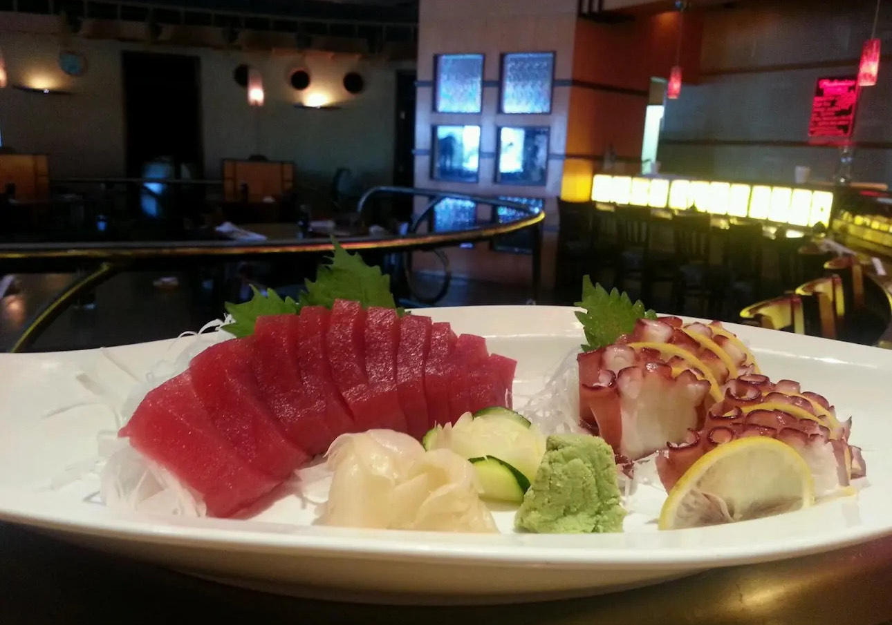 Sashimi platter with tuna, octopus, wasabi, ginger, and lemon.