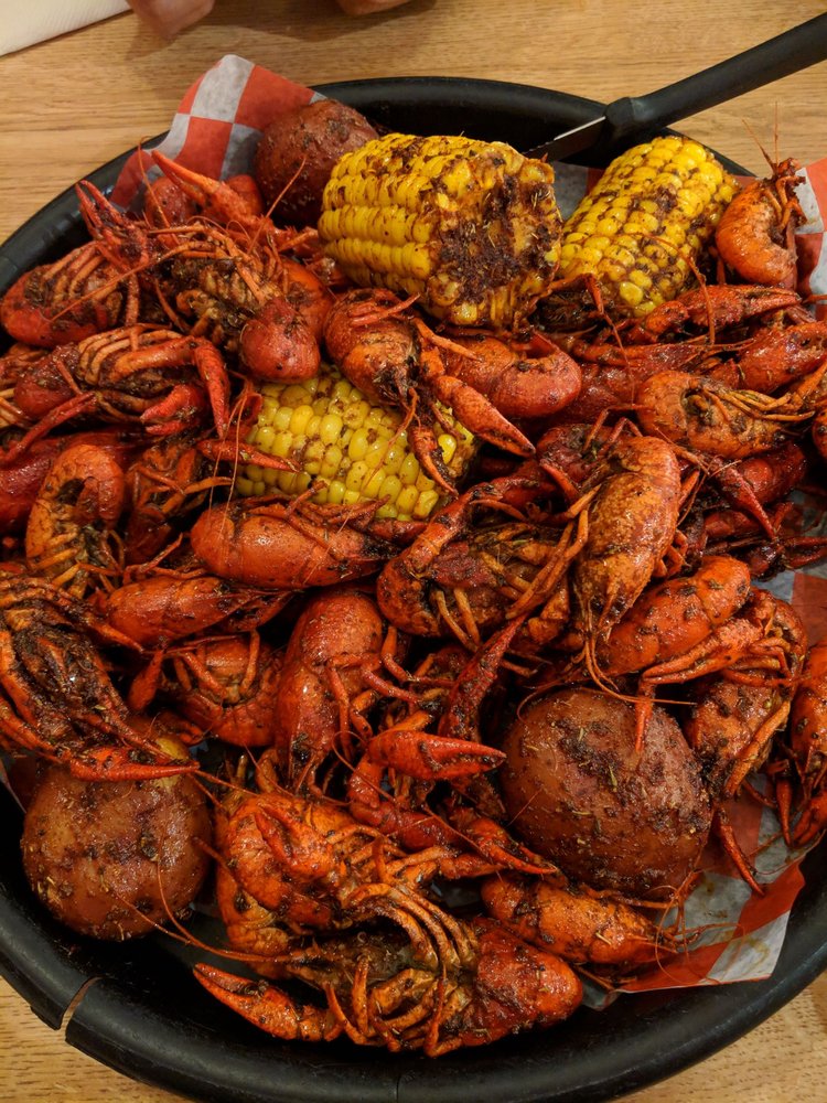 Platter of seasoned crawfish, corn on the cob, and potatoes.