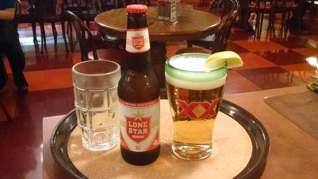 Bottle of Lone Star and glass of Dos Equis beer with lime.