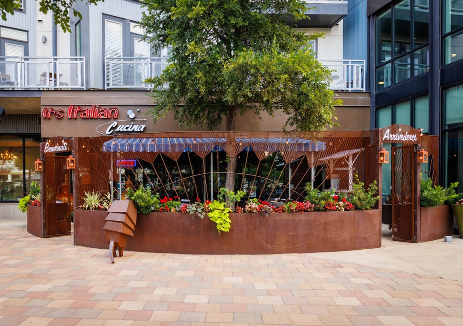 Rusted metal patio with flowers outside It's Italian Cucina restaurant.