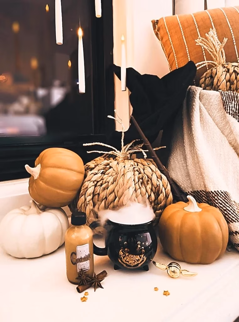 Harry Potter themed autumn display with pumpkins, steaming cauldron, and floating candles.