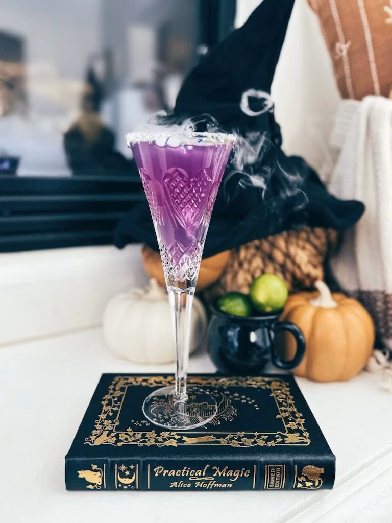 Purple smoking drink on "Practical Magic" book with witch's hat.