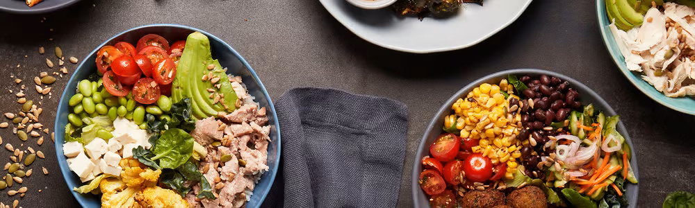 Several vibrant food bowls featuring vegetables, proteins, and grains.