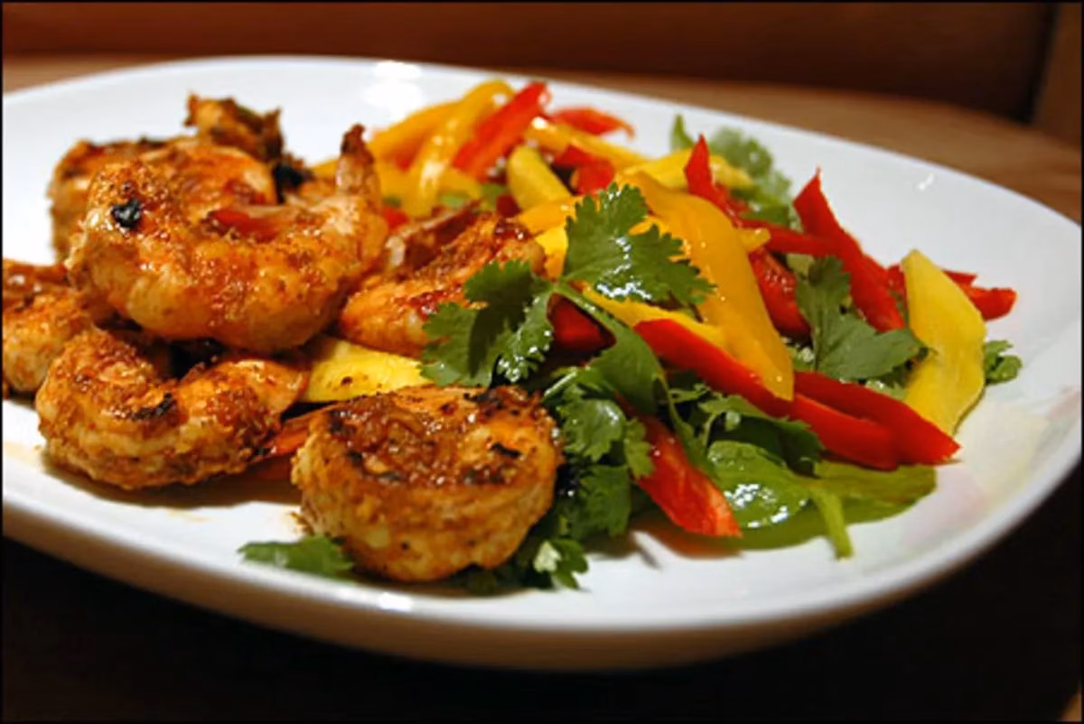 Cooked shrimp served with mango, bell pepper, and herb salad.