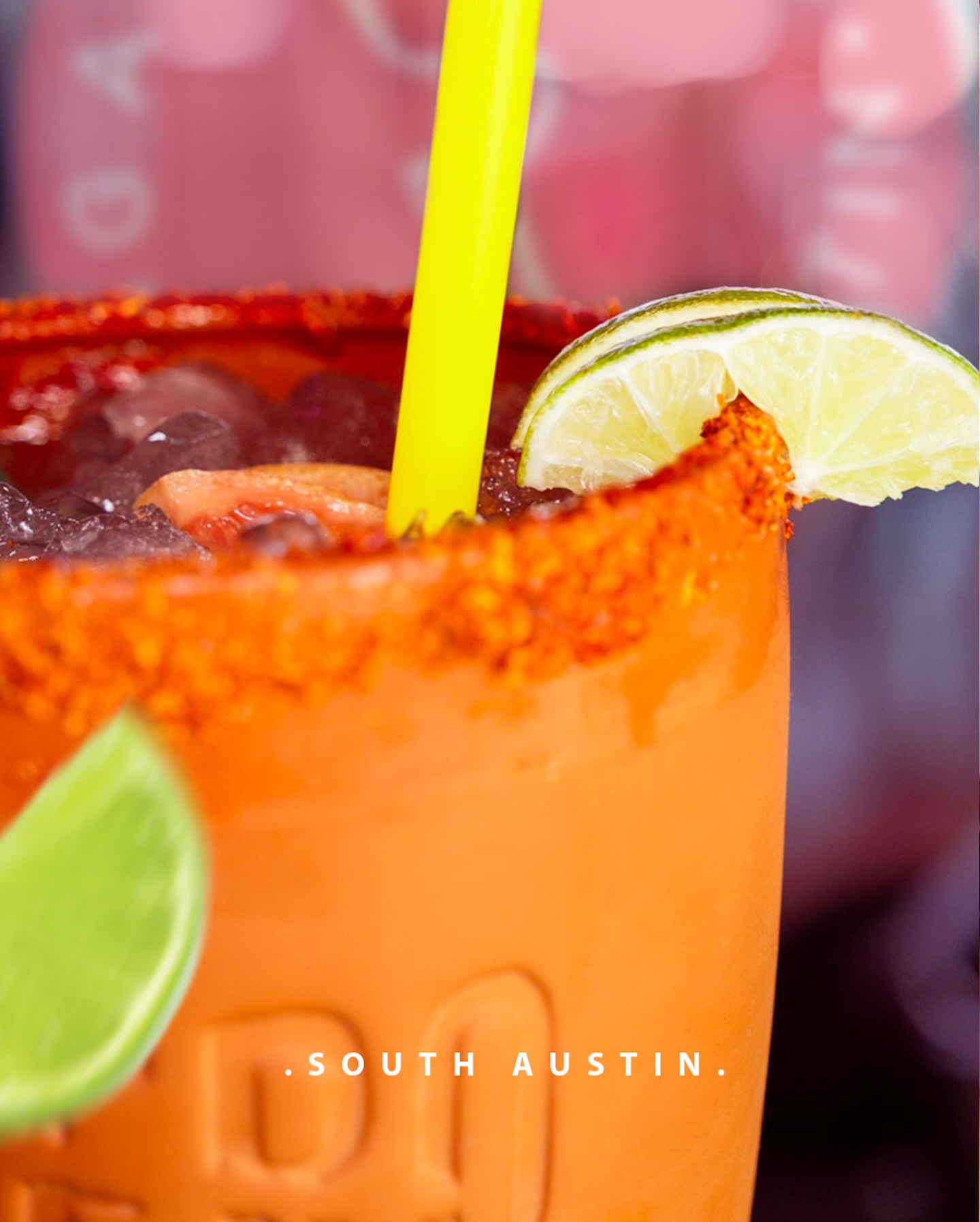 Orange drink with spiced rim, lime, ice, straw, and 'SOUTH AUSTIN' text.