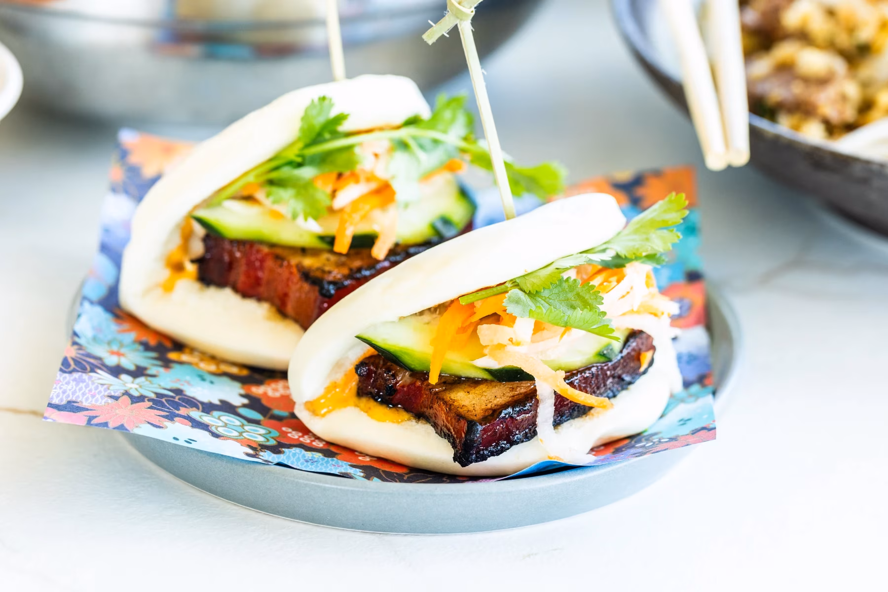 Bao buns with pork belly, cucumber, pickled vegetables, cilantro.