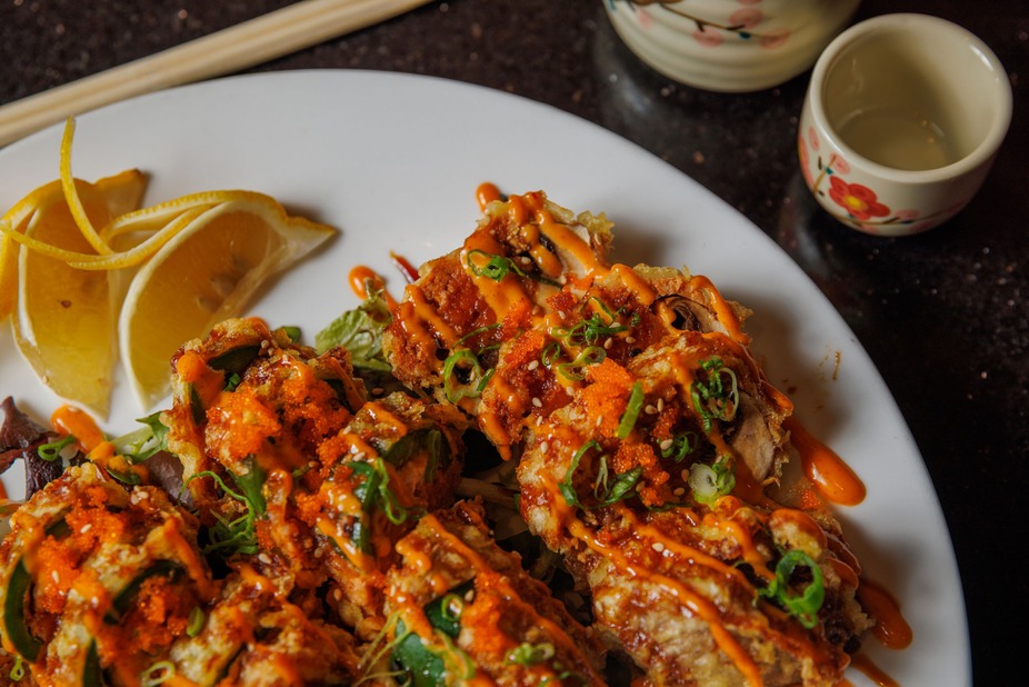 Fried dish with orange sauce, orange roe, green onions, and lemon.