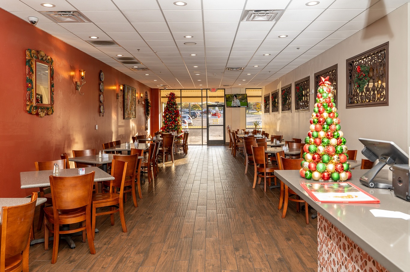 Dining room interior with tables, chairs, Christmas trees, and a service counter.