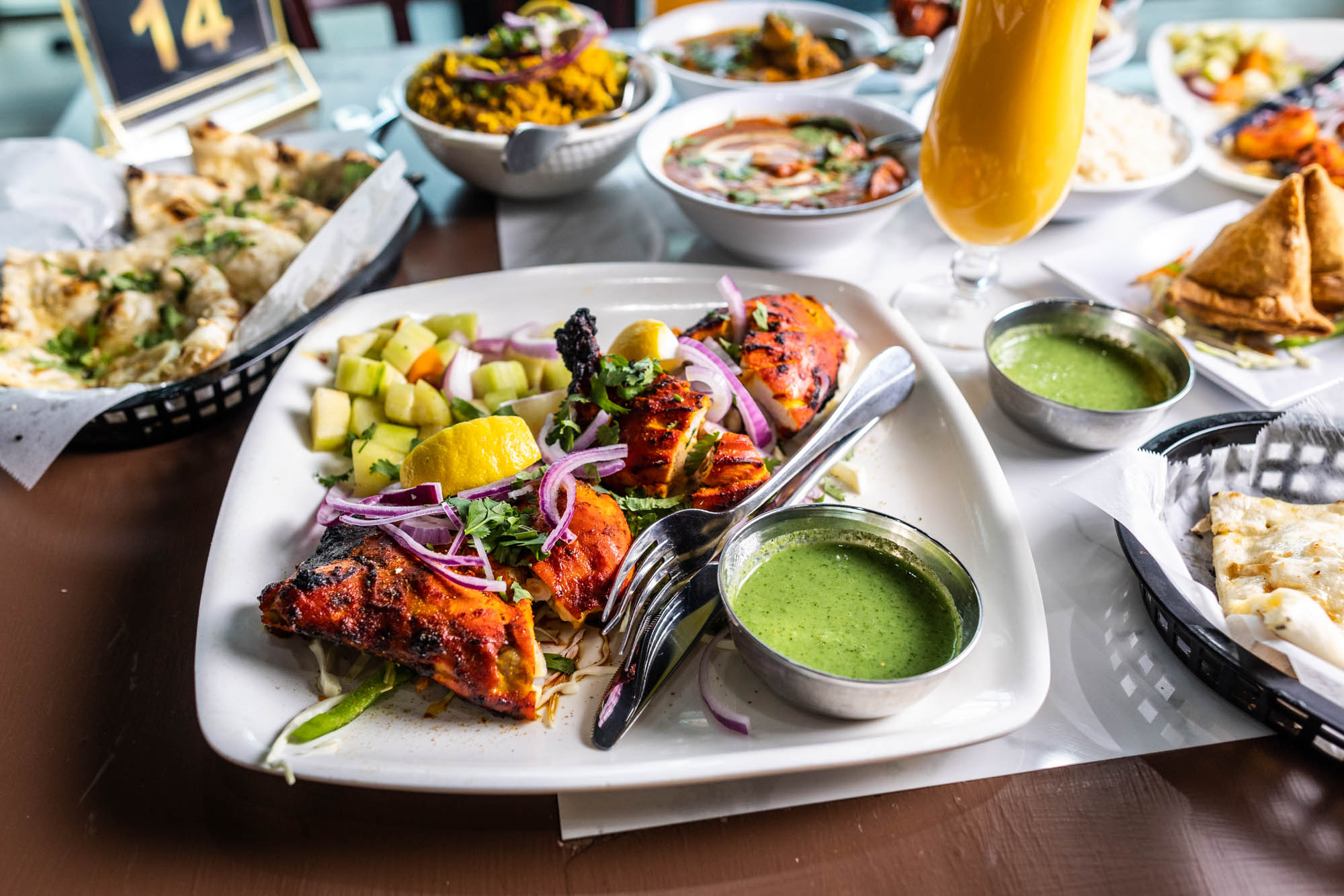 A spread of Indian dishes, including tandoori chicken, naan, and curries.