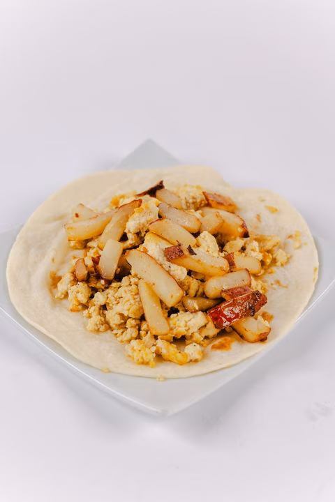 Open tortilla with scrambled filling and browned potato slices.
