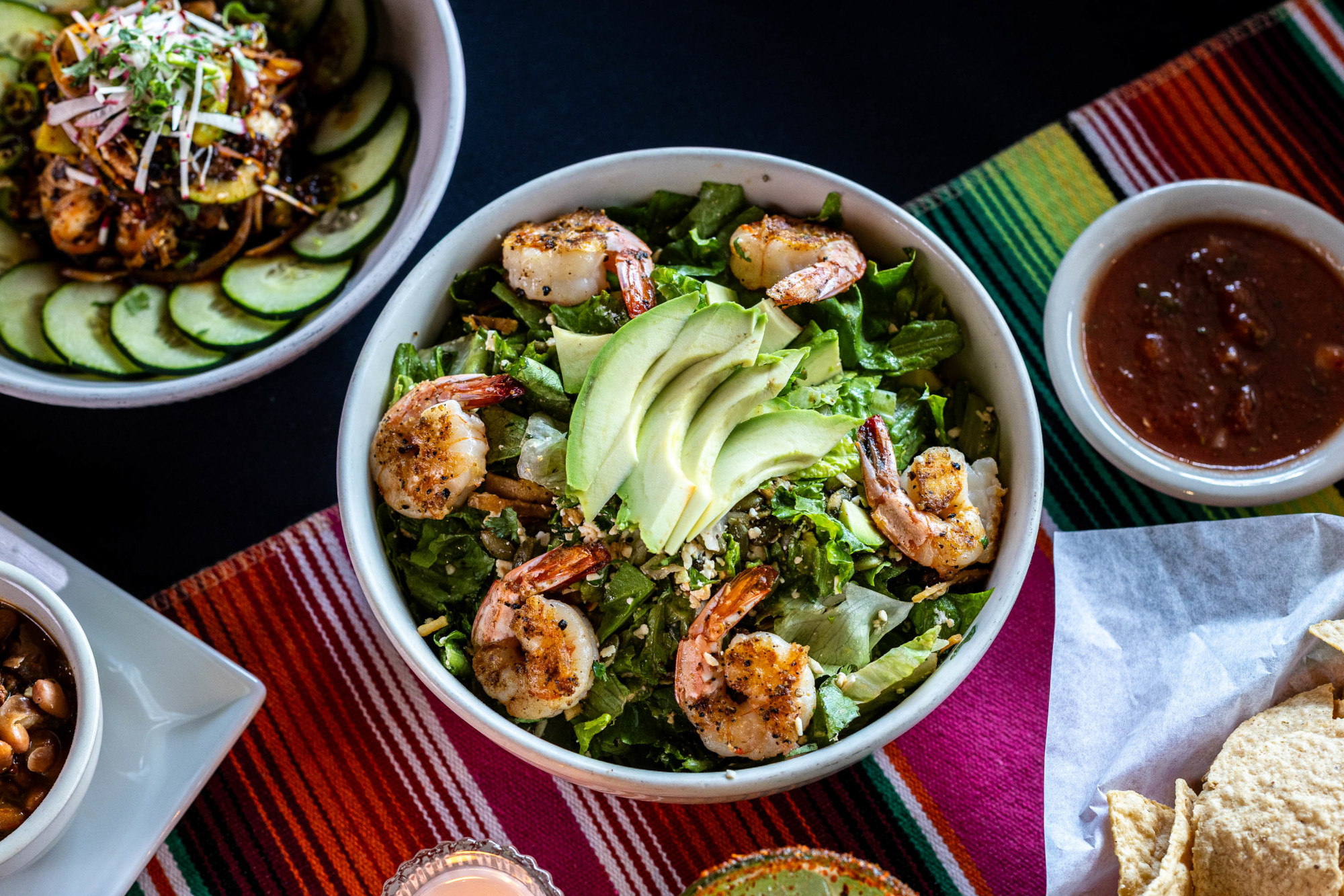 Shrimp and avocado salad, with salsa, tortilla chips, and other dishes.