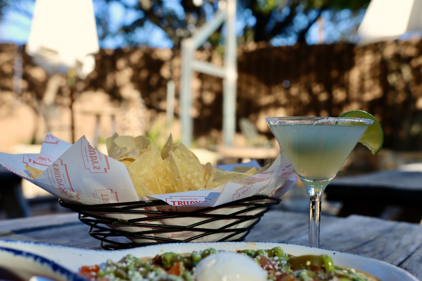 Trudy's tortilla chips and a salted margarita on an outdoor table.