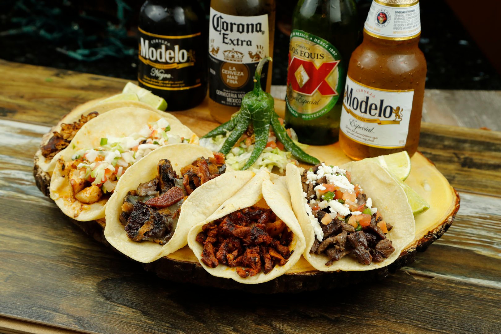Six tacos with assorted fillings, lime, chiles, and four Mexican beers.