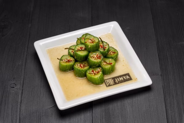 Cucumber slices with chili flakes and sesame seeds in a light sauce.