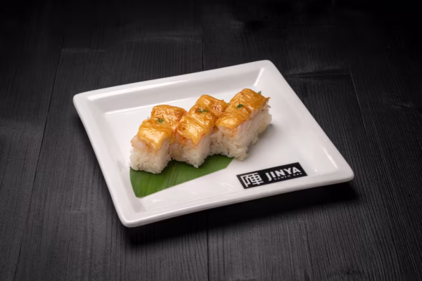 Three nigiri with seared topping on white plate with Jinya logo.