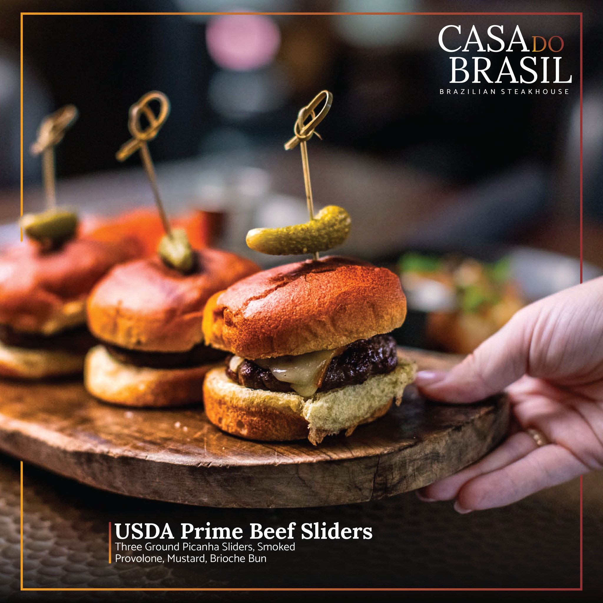 Three USDA Prime beef sliders on a wooden board.