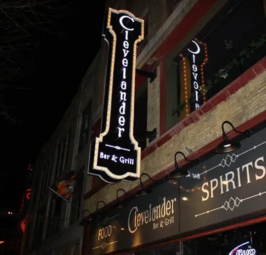Illuminated Clevelander Bar & Grill signs on building exterior at night.