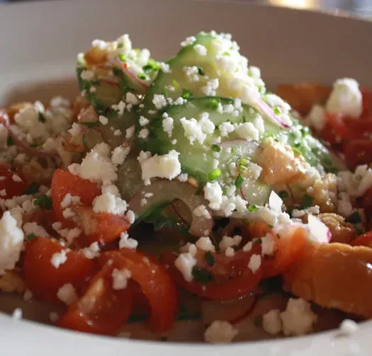 Fresh panzanella-style salad with tomatoes, cucumber ribbons, and feta.