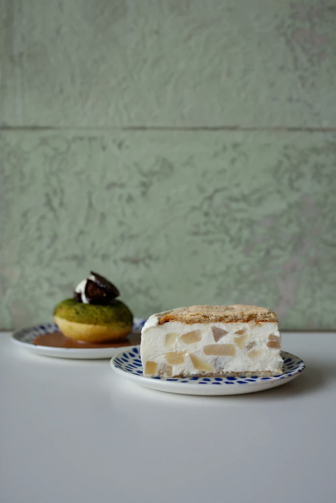 Two distinct desserts: fruit-filled slice and green-topped pastry in sauce.