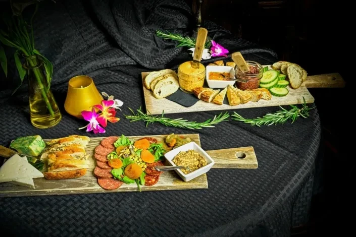 Rustic wooden boards with an elaborate charcuterie spread and elegant decor.