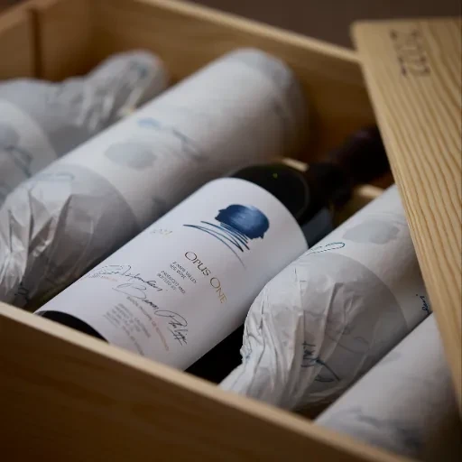 Opus One Napa Valley wine bottle, blue label, in wooden crate.