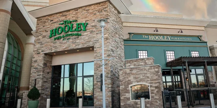 Exterior of The HOOLEY PUB & KITCHEN building with a faint rainbow.