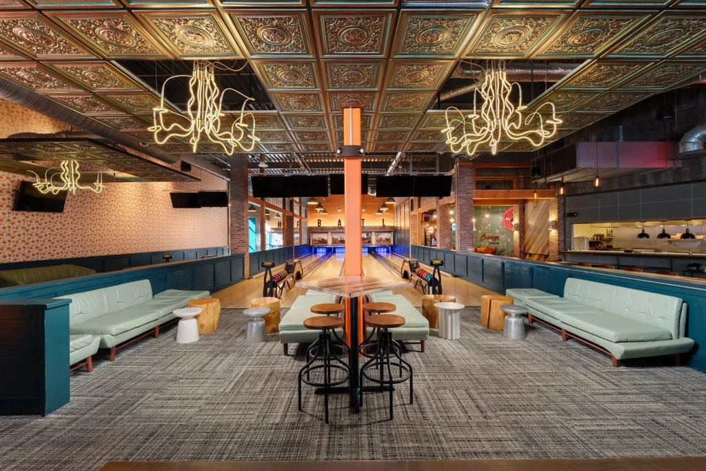 Empty modern bowling alley and restaurant with industrial-chic decor.
