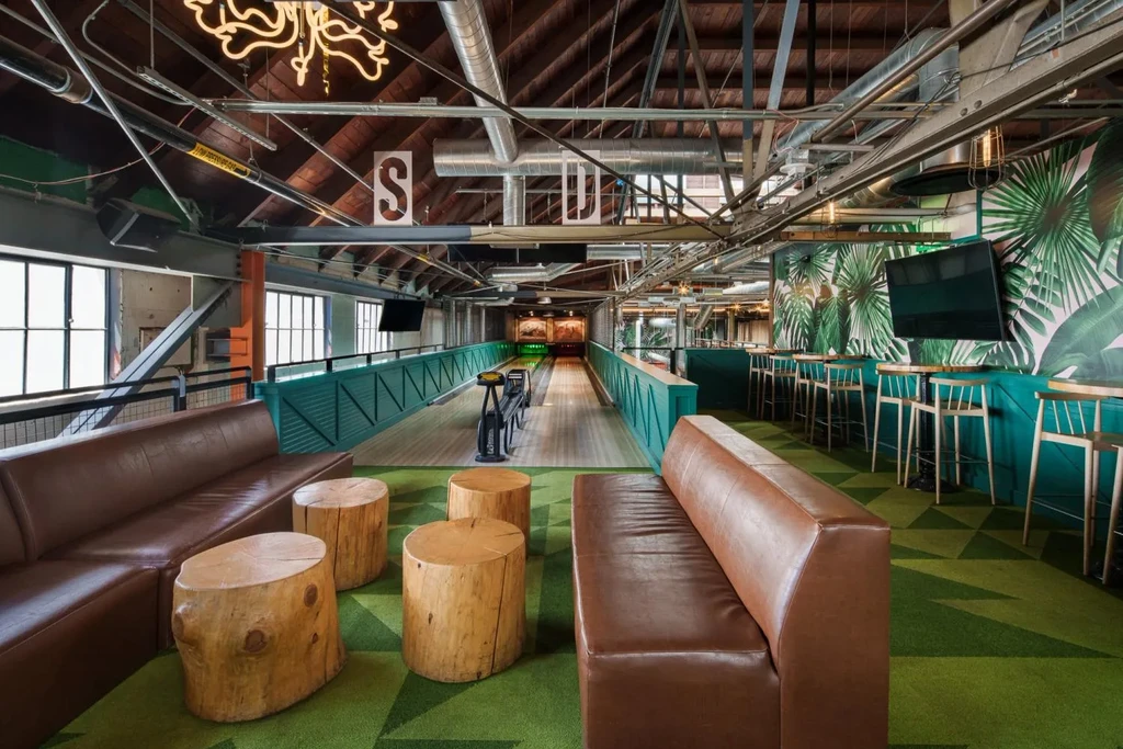 Modern interior with mini-bowling alley, bar, and industrial-chic design.