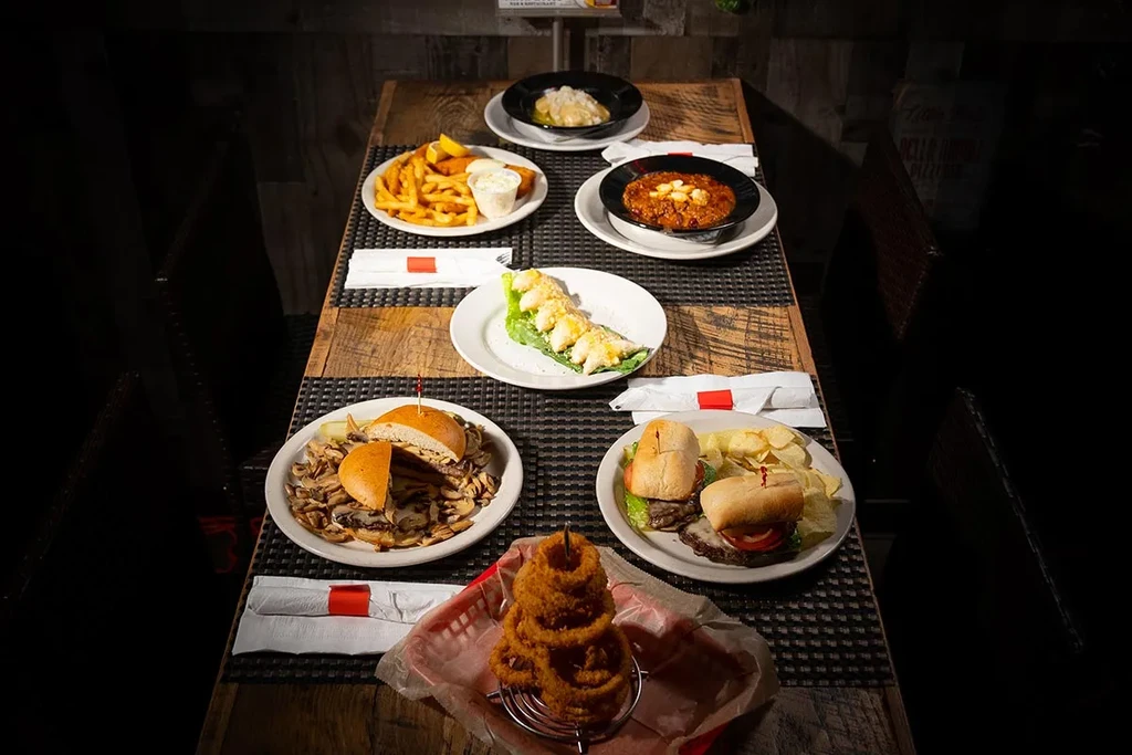 Overhead shot of a rustic table laden with casual restaurant food.