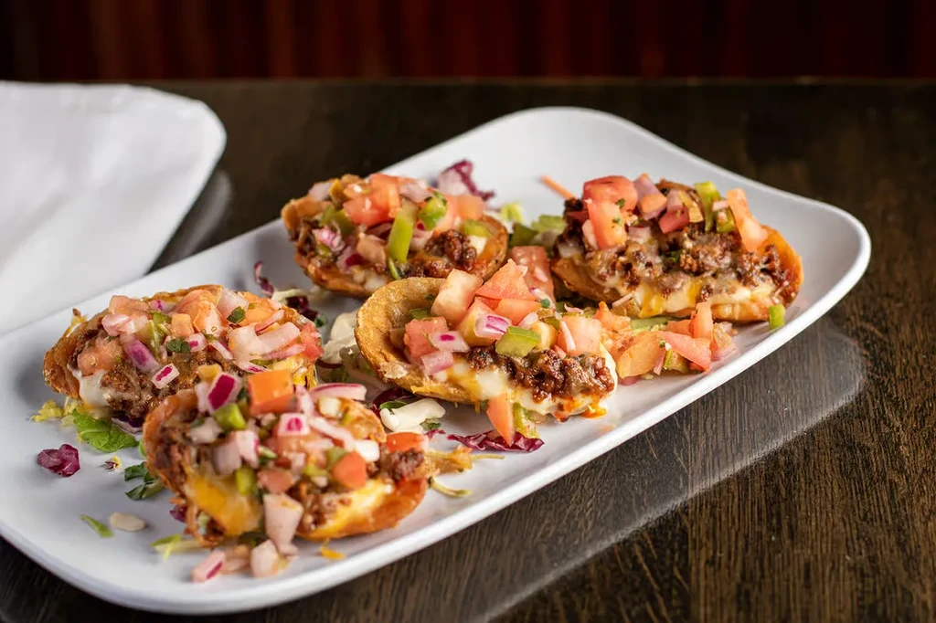White platter of five crisp, cup-shaped meat, cheese, and salsa appetizers.