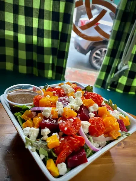 A vibrant salad bowl with roasted vegetables and crumbled feta.