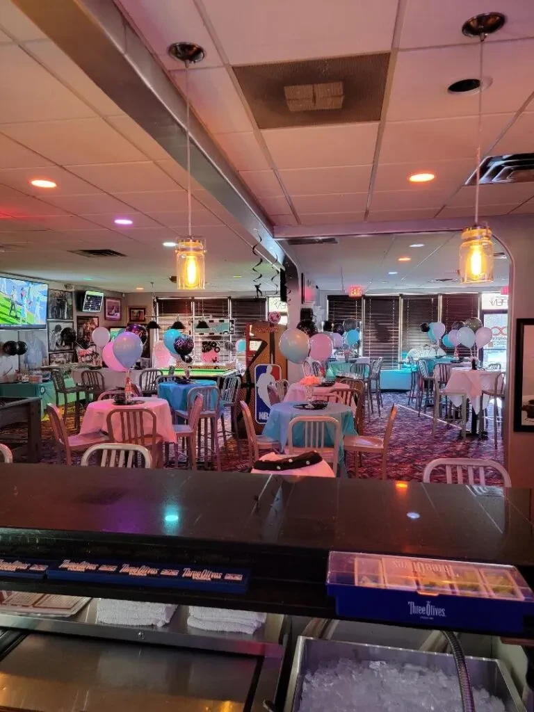 Restaurant or bar interior decorated with balloons and streamers for a party.