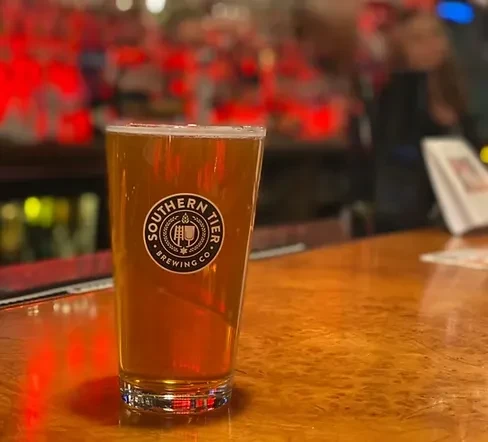 Pint glass of Southern Tier beer on a wooden bar.