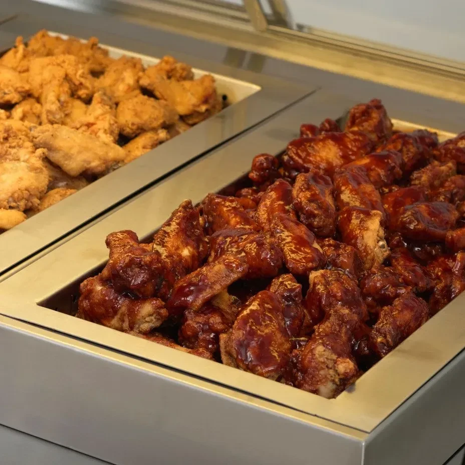 Two buffet trays: BBQ chicken wings and golden-brown fried chicken.