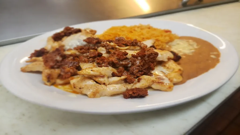 Grilled chicken and chorizo with rice and cheesy refried beans.