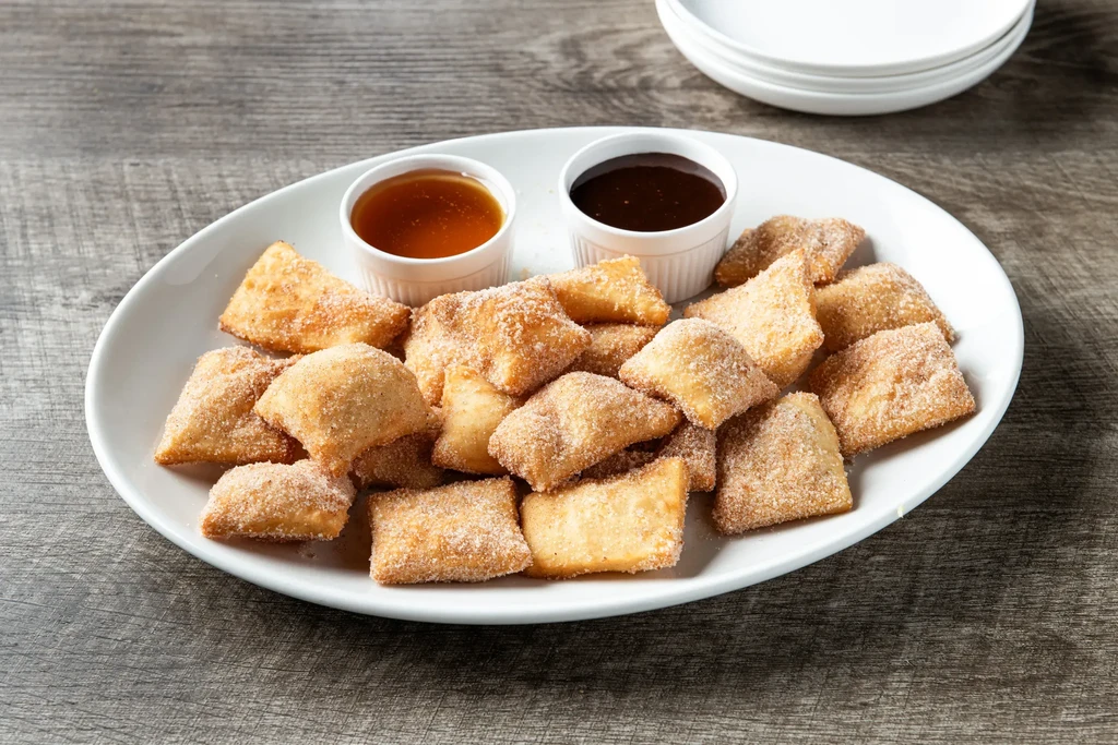 Cinnamon sugar fried dough with caramel and chocolate sauces.